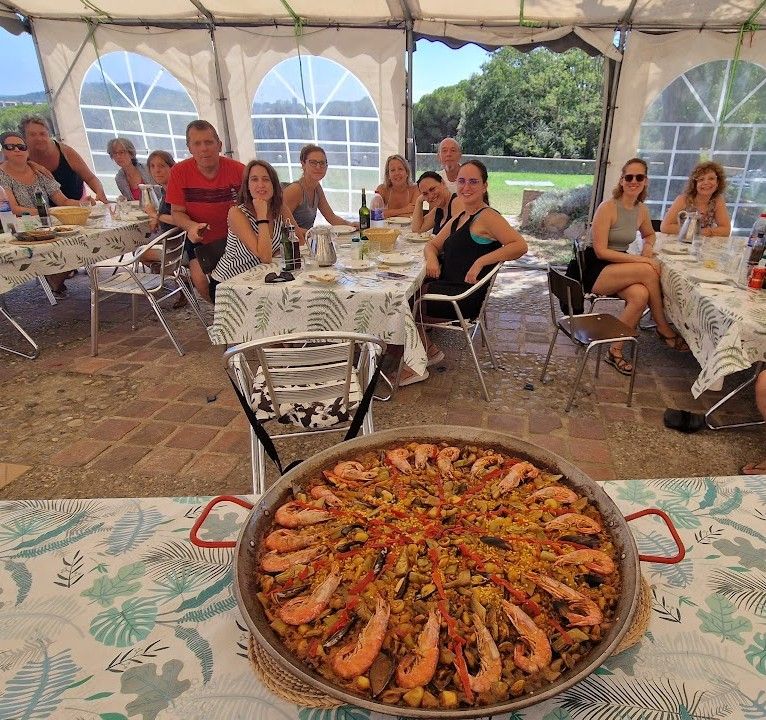 Grupo compartiendo una comida durante un retiro de bienestar y vacaciones alternativas en la Costa Brava