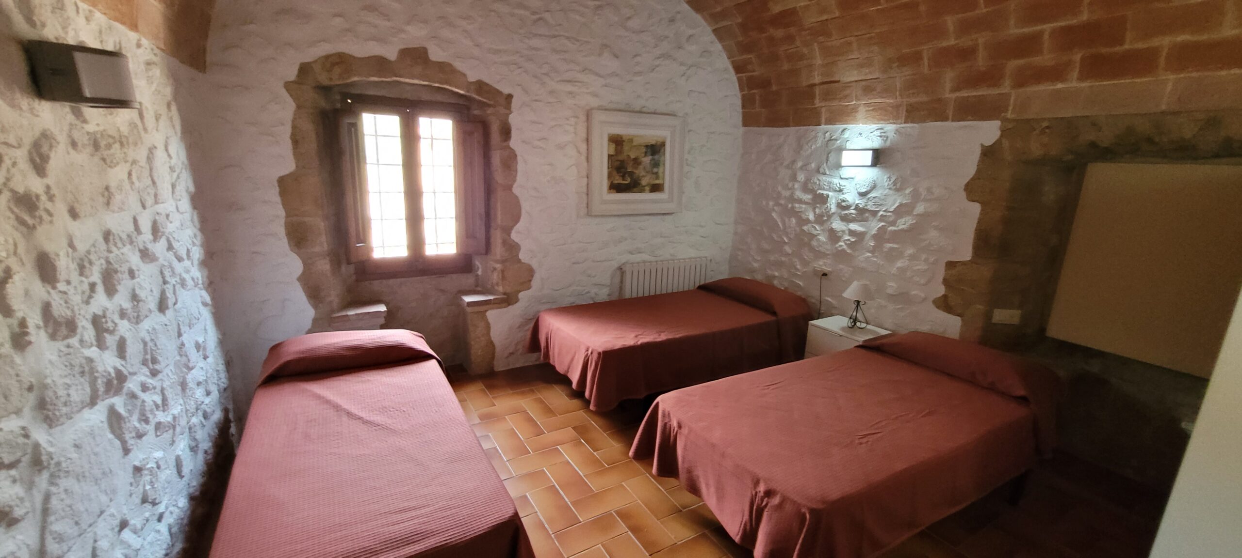 Habitación triple de Mas Dausà en Castell d'Aro con techo de volta catalana para los participantes del retiro