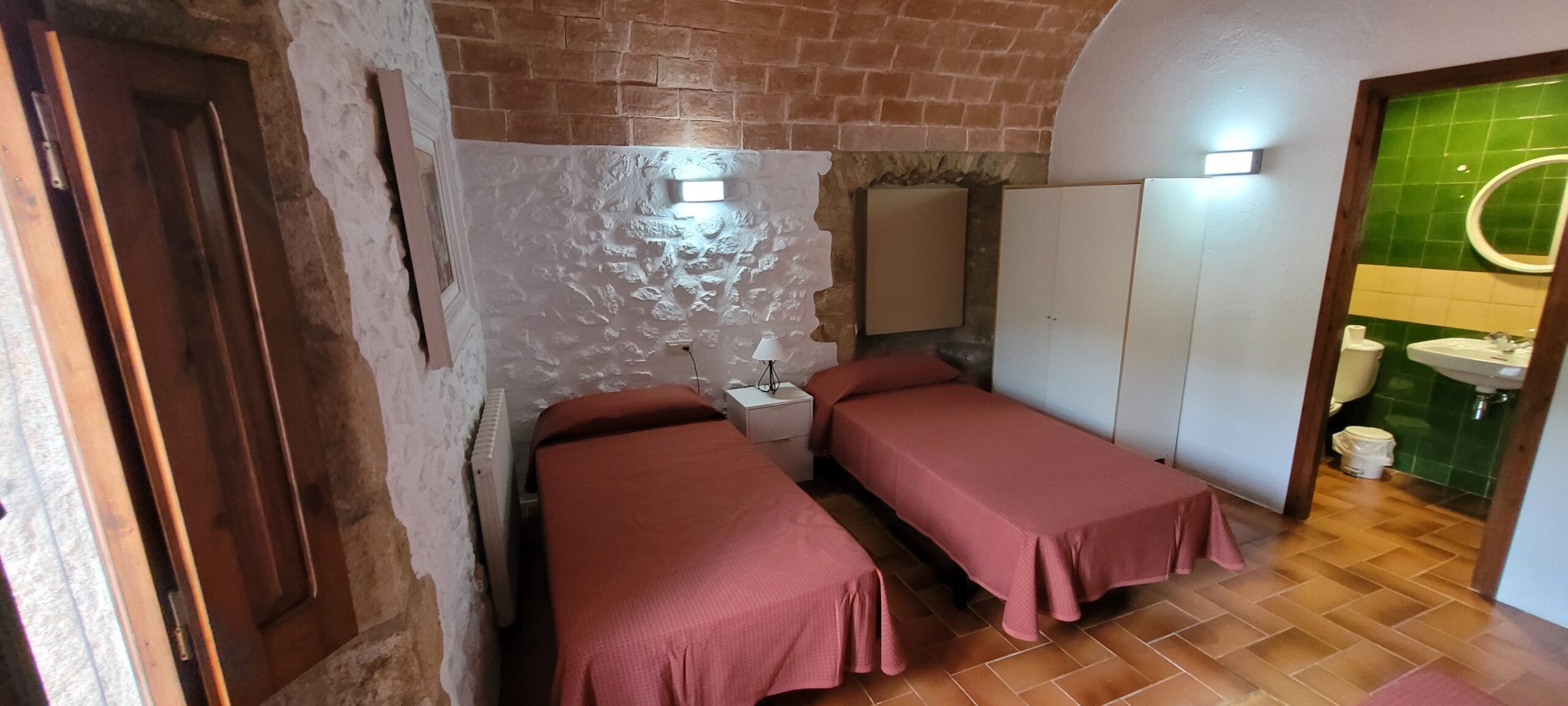 Habitación triple de Mas Dausà en Castell d'Aro con camas individuales para alojamiento del retiro Reval