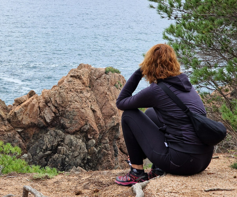 Persona disfrutando de un momento de calma junto al mar durante unas vacaciones alternativas en la Costa Brava